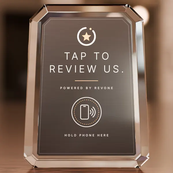 Front view of the crystal standee: Revone star mark, Tap to review us, and a ringed phone icon labelled Hold phone here.